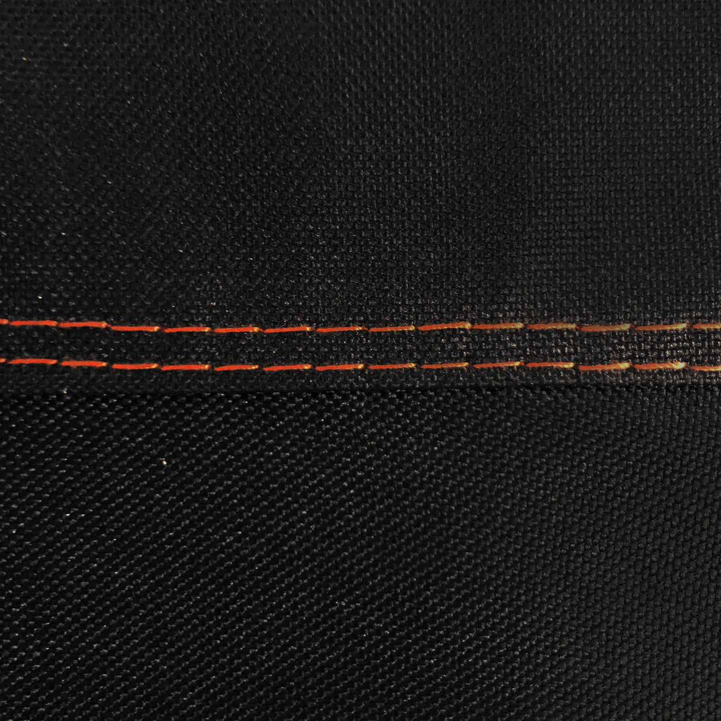 Close-up of black fabric with red stitching detail