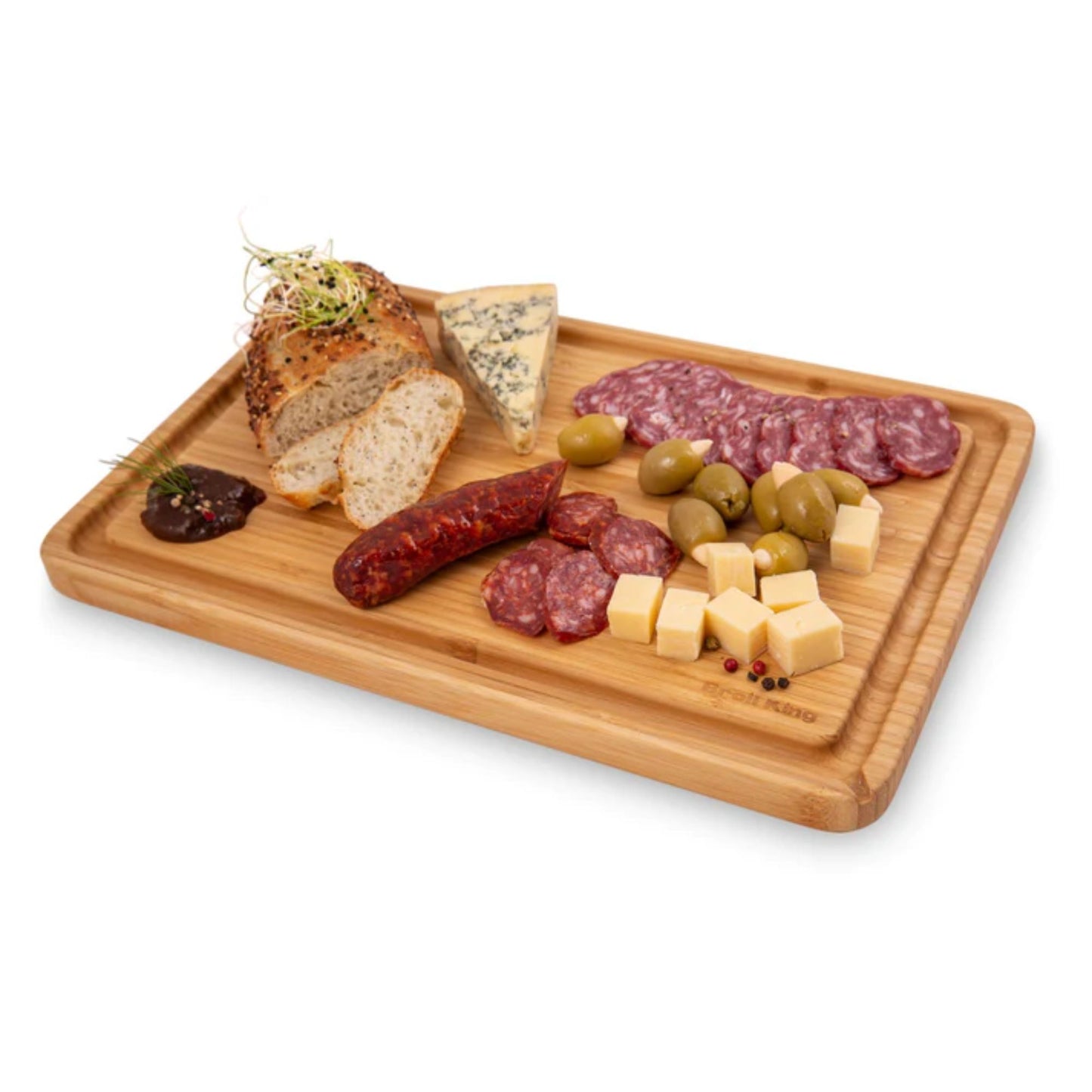 Wooden cutting board with assorted meats, cheeses, and olives on a white background