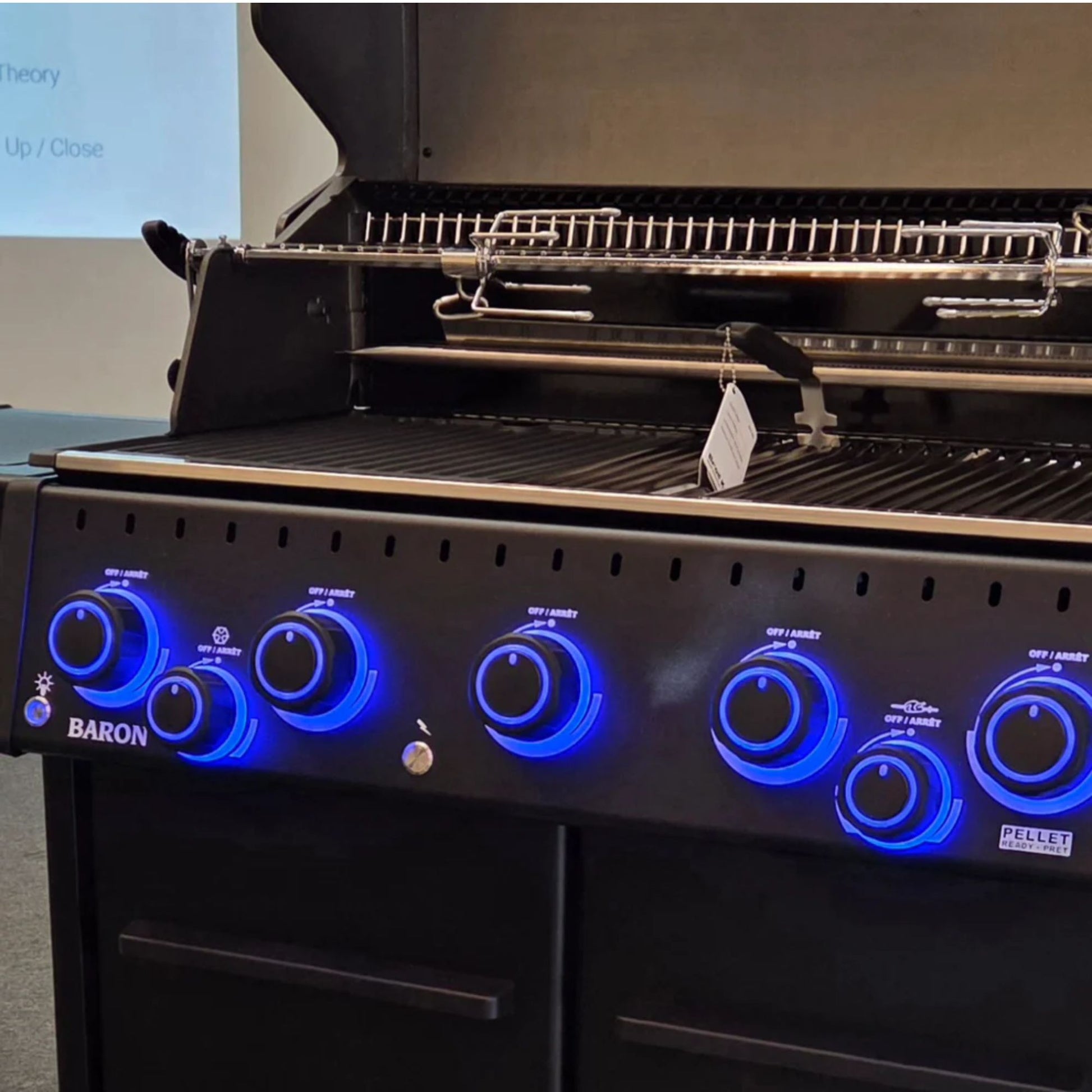 Close-up of illuminated control knobs and cooking area on the Broil King Baron 590 IRX Shadow Gas BBQ with rotisserie system.