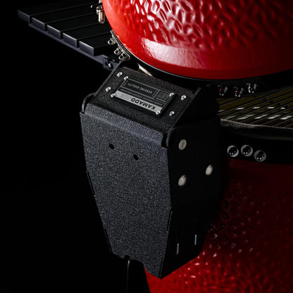 Close-up of a Kamado grill with a black side shelf on a dark background