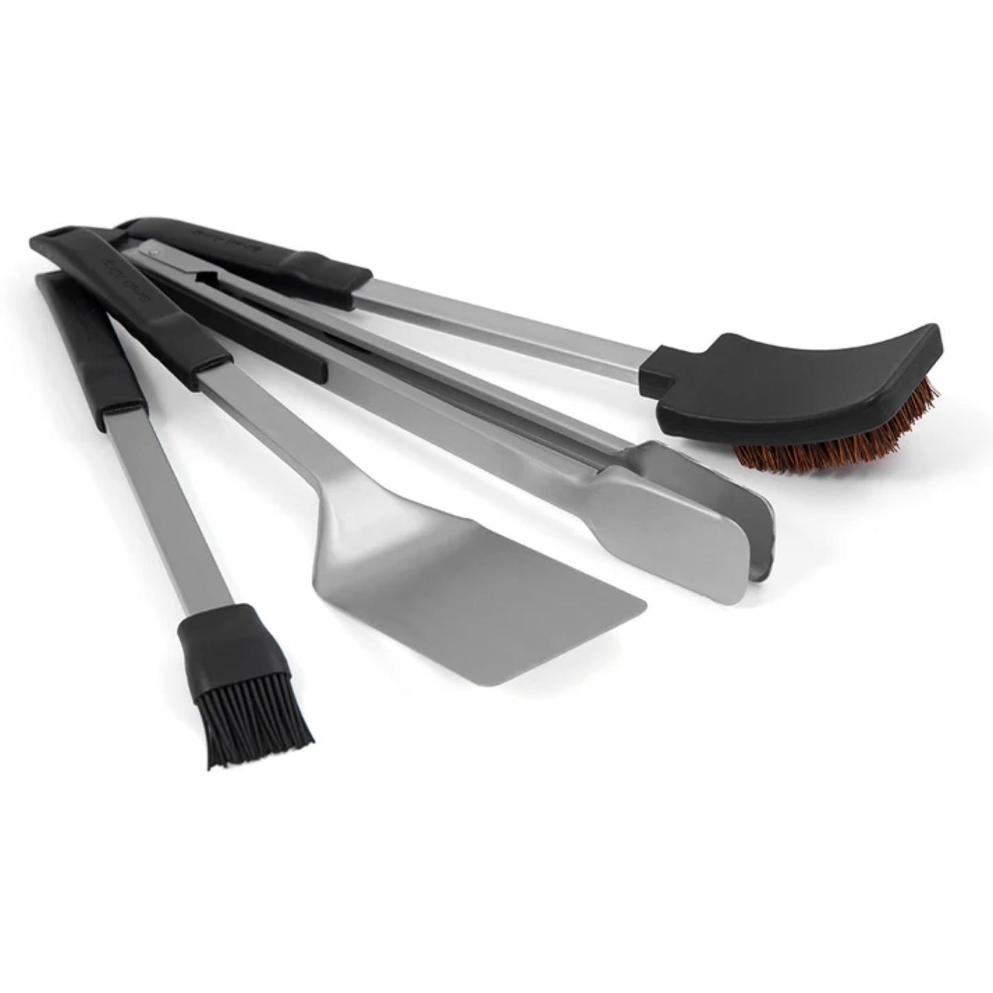 Set of barbecue tools including tongs, spatula, and brush on a white background