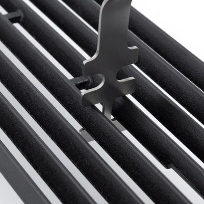 Close-up of a black metal grill with a grid lifter component.