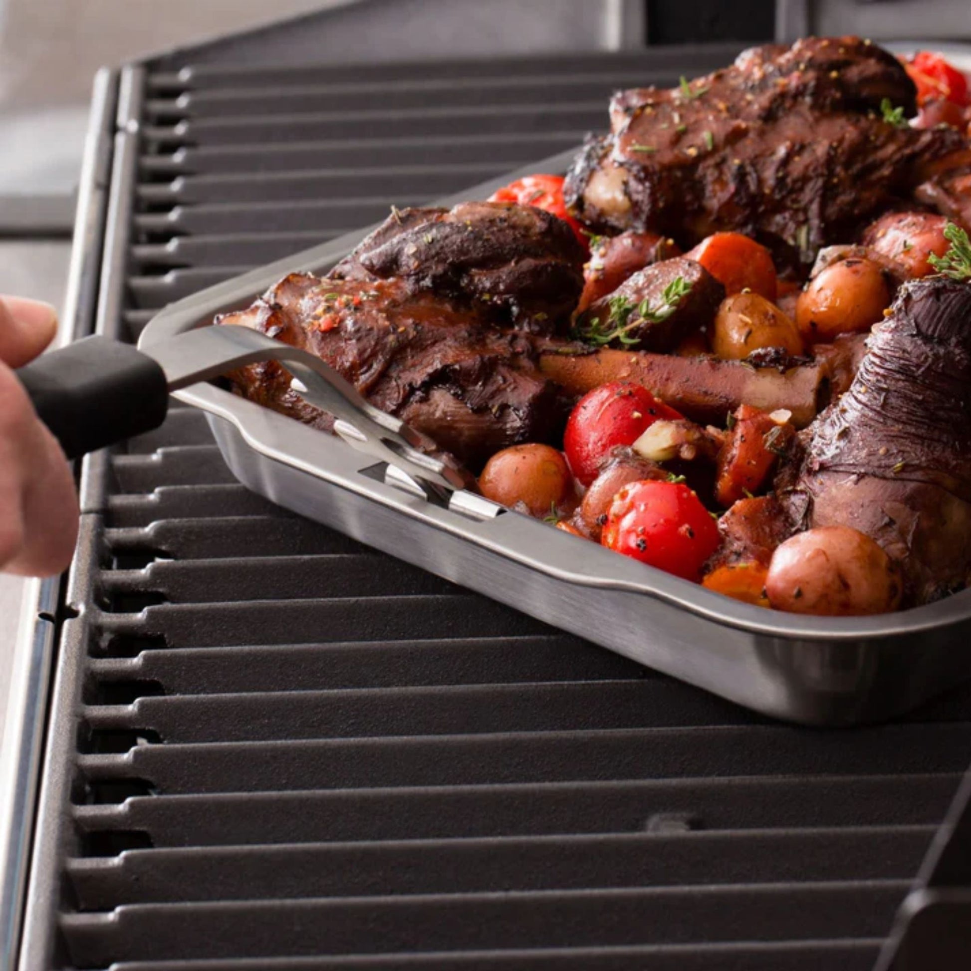 Grilled meat and vegetables on a pan over a grill