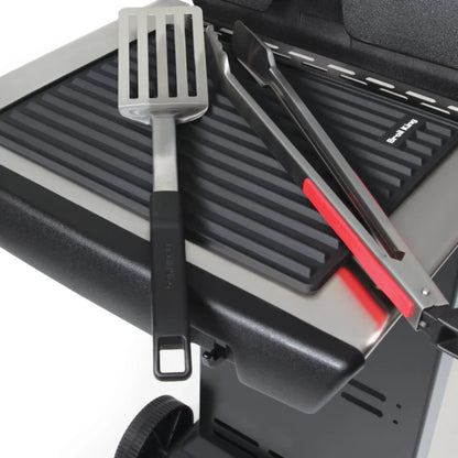 Grill with utensils and silicone mat on a white background