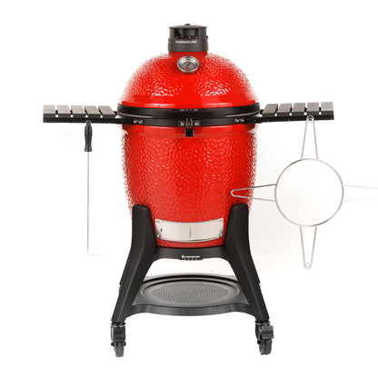 Red Kamado grill with black stand on a white background