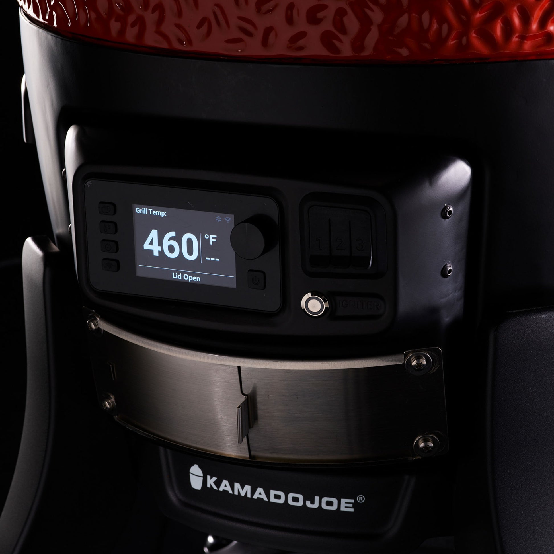 Close-up of a Kamado Joe grill with digital temperature display on a dark background
