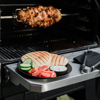 Grilled chicken, vegetables, and a plate of food on a portable grill.