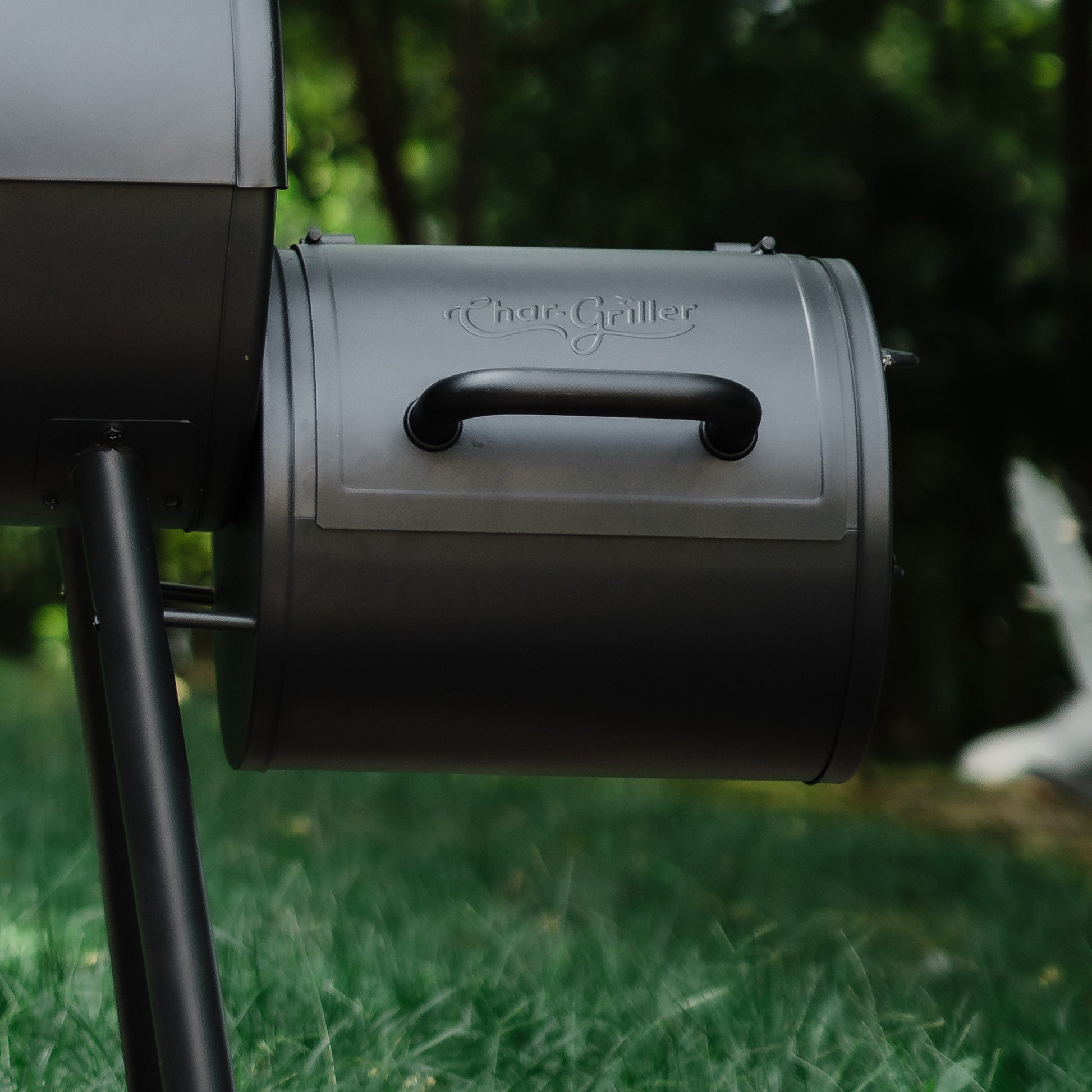 Charcoal grill with 'Char-Griller' branding on a grassy background