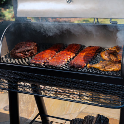 Barbecue grill with various meats cooking outdoors