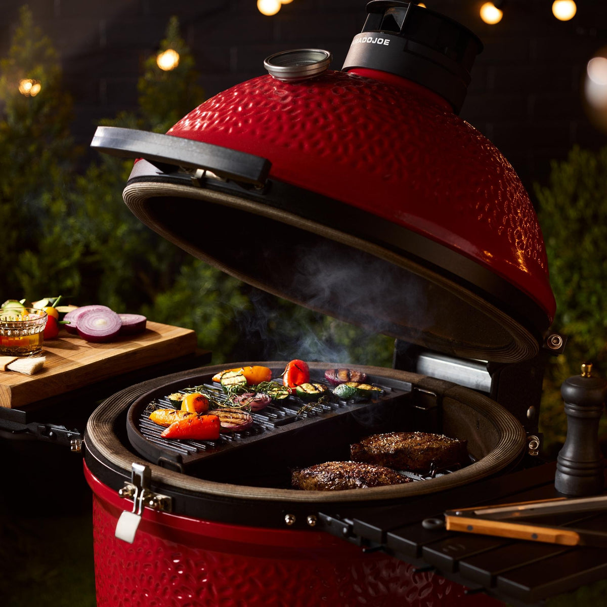 Red Kamado-style grill with food cooking on an outdoor setting
