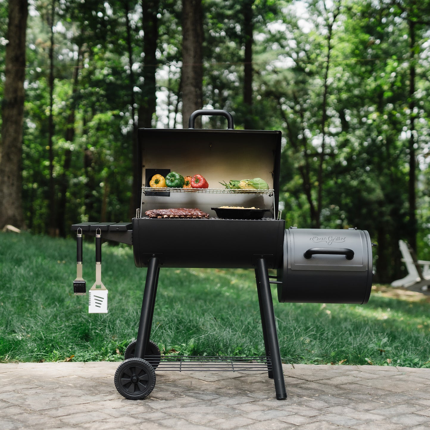 Black barbecue grill with food on it in a garden setting